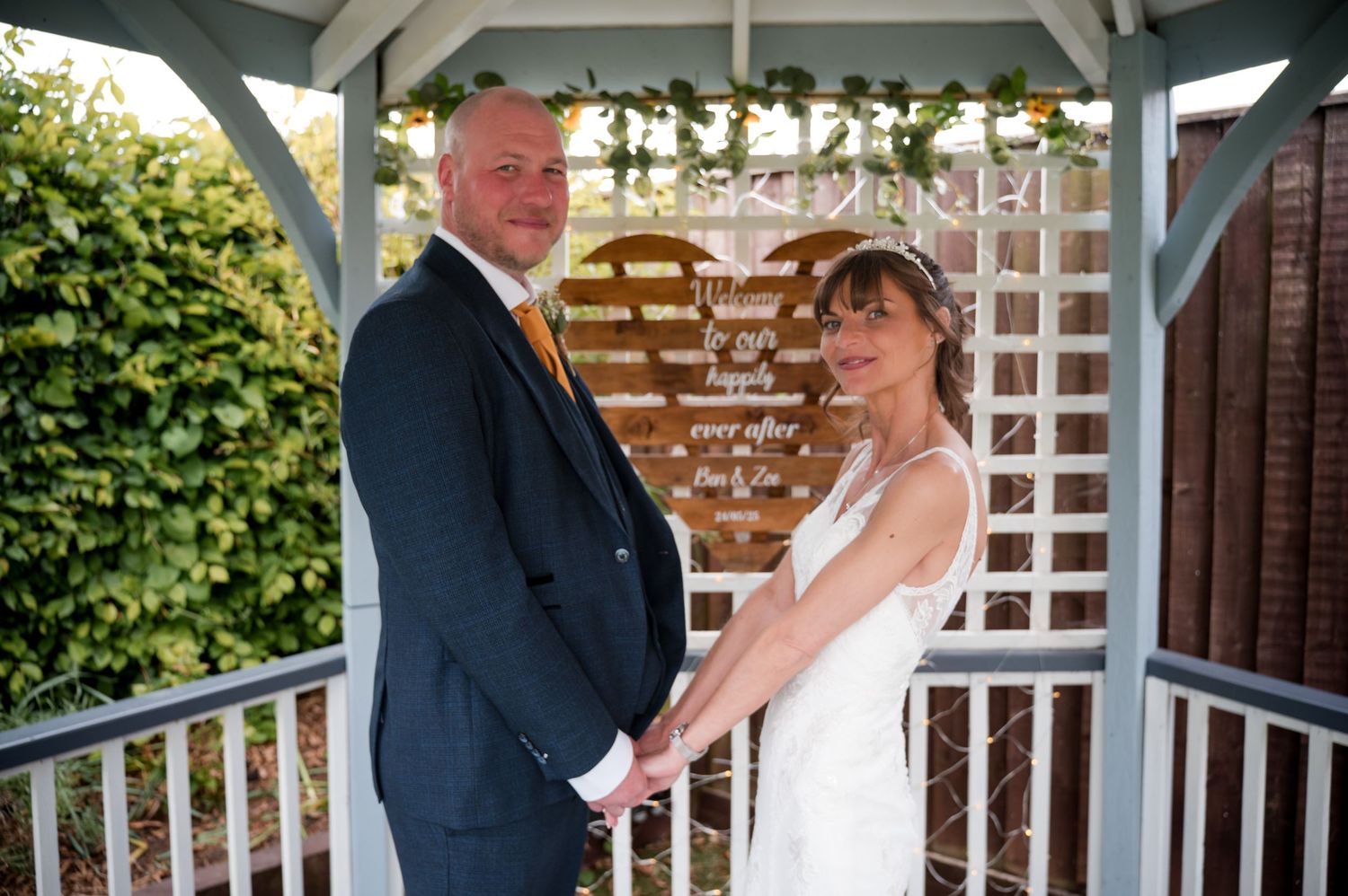 A couple shares tender moments during their wedding ceremony at a white gazebo venue.