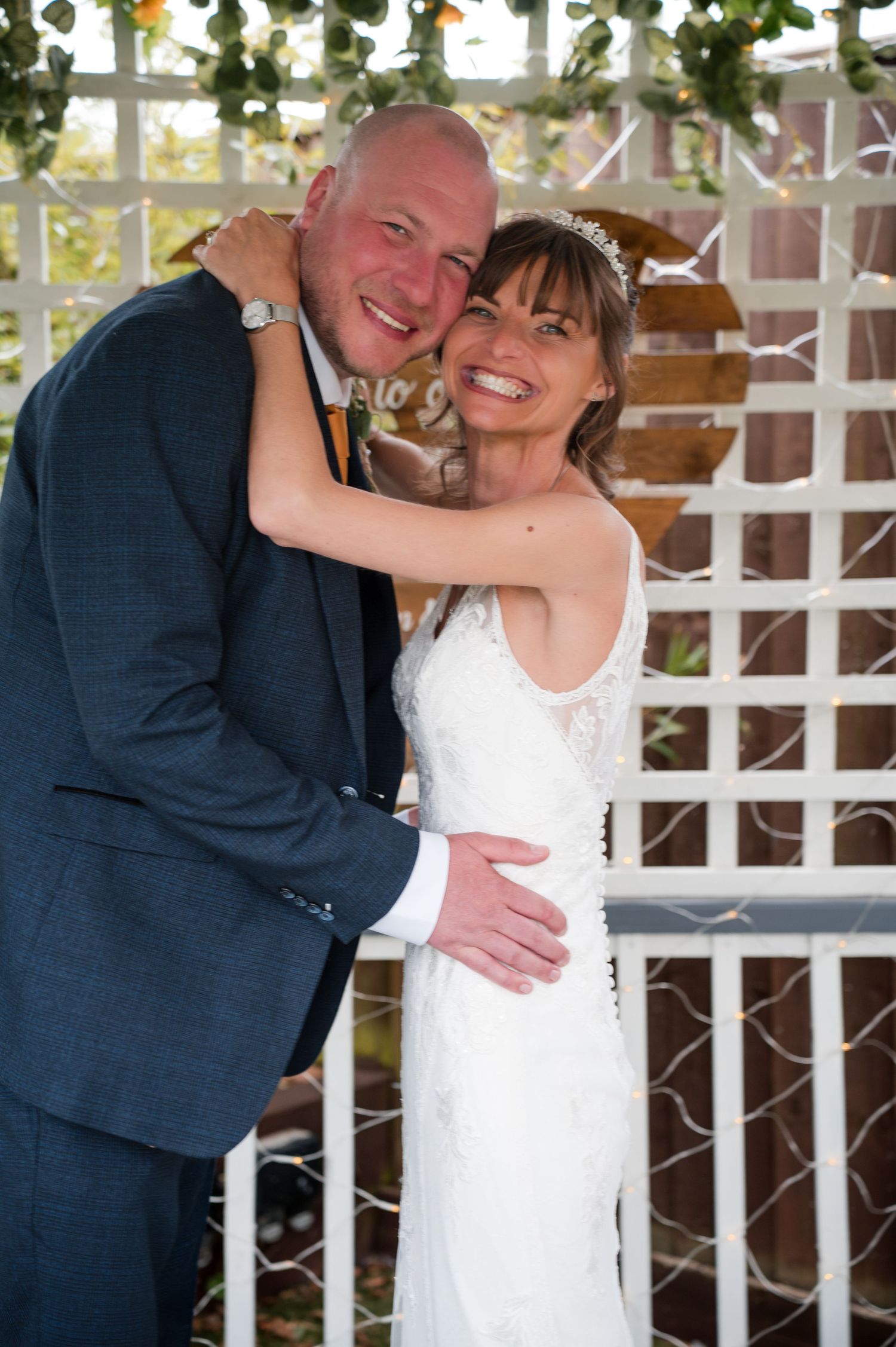 A joyful wedding moment captured in a series of photos showing a couple embracing against a white lattice backdrop.