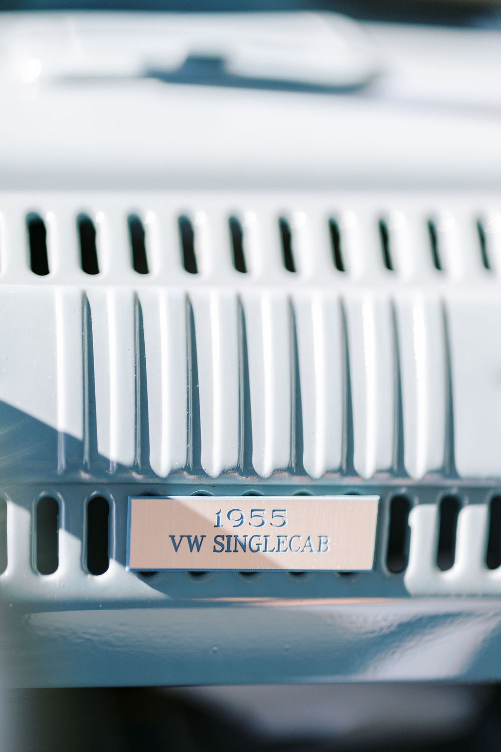 Close-up detail of a 1955 VW Single Cab badge on a vintage Volkswagen vehicle.