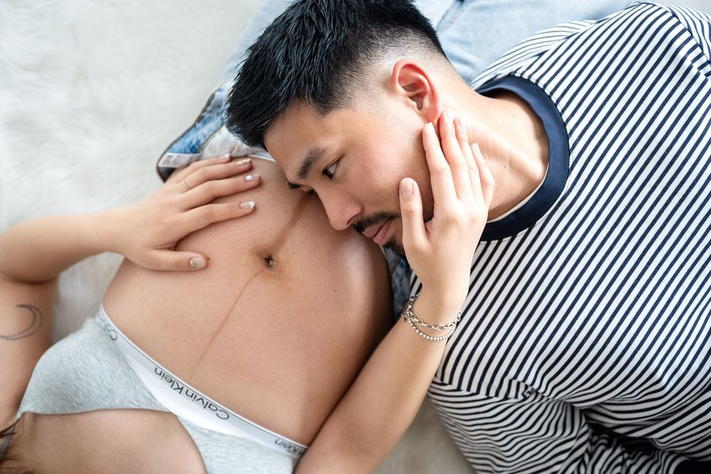 Two men lying together in an intimate embrace, one wearing Calvin Klein underwear.