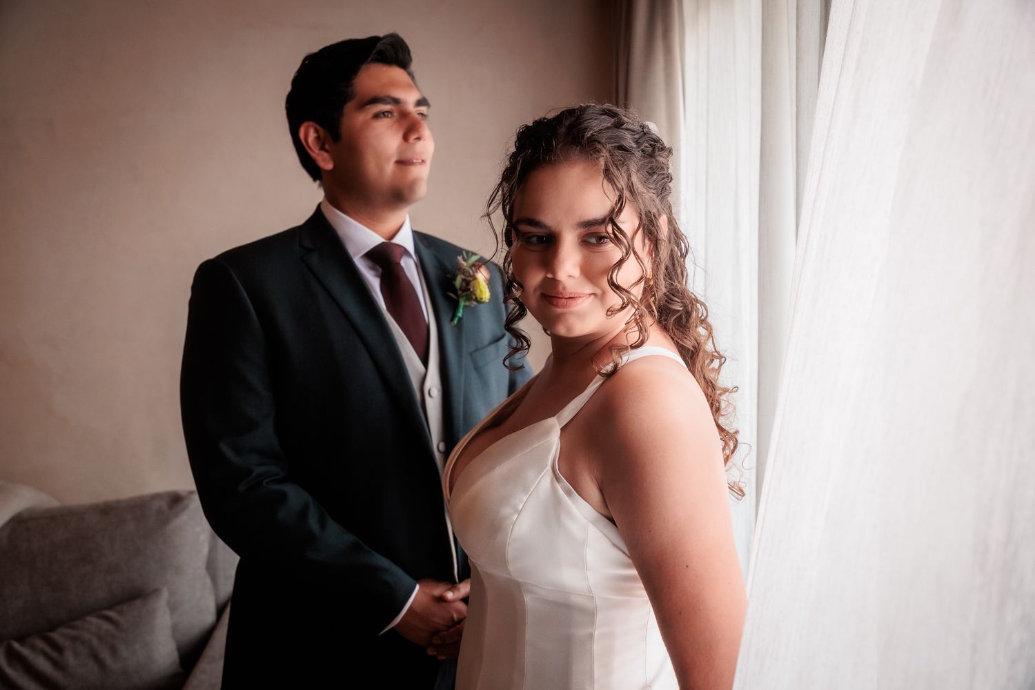Romantic portrait session by window light creating soft, intimate moments.