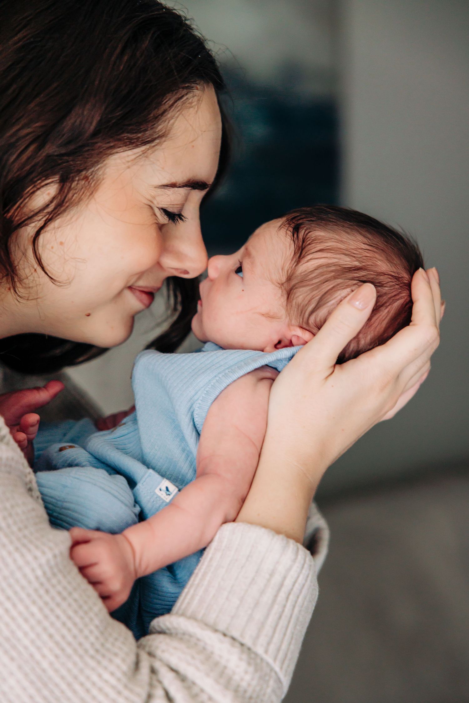 A tender moment captured in a series of intimate photos showing a parent bonding with their newborn baby.