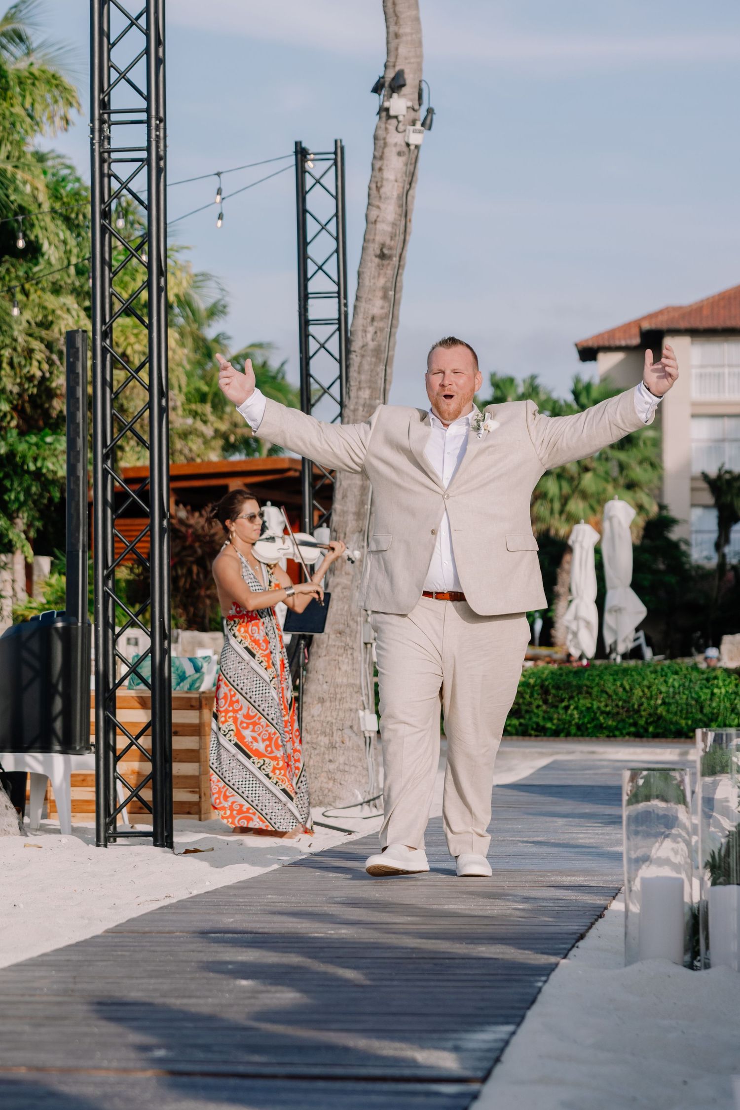 Wedding celebration on outdoor deck with palm trees and festive atmosphere.