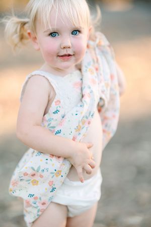 Close-up shots of a toddler in a floral outfit with delicate details.