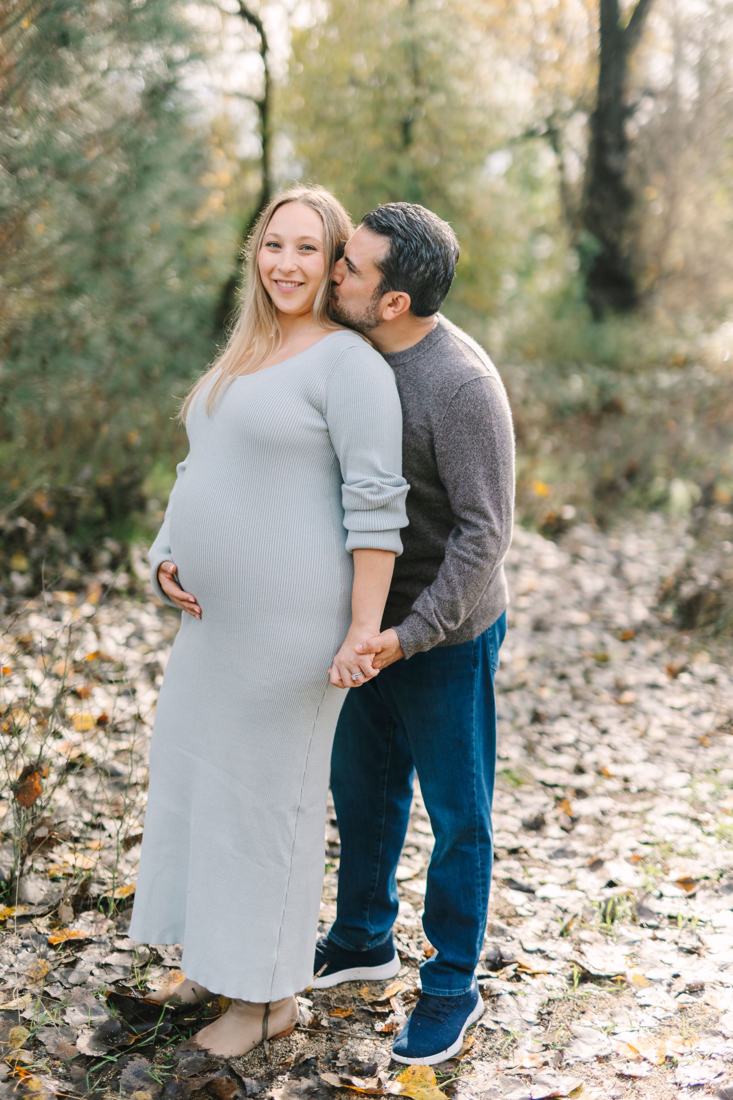 Maternity photo sequence showing a couple embracing outdoors among fallen autumn leaves.