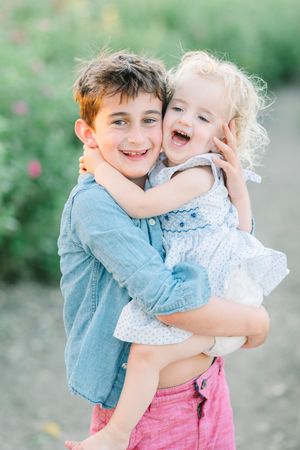 Sweet sibling moment shared outdoors with natural lighting.