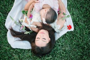 Family members lying on grass during a relaxed outdoor portrait session.