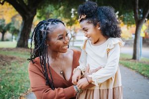A joyful family moment captured outdoors in a park with warm autumn lighting and natural expressions.