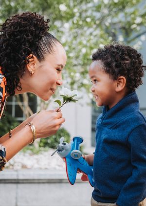 A tender moment shared between parent and child in a series of five connected photos outdoors on a sunny day.