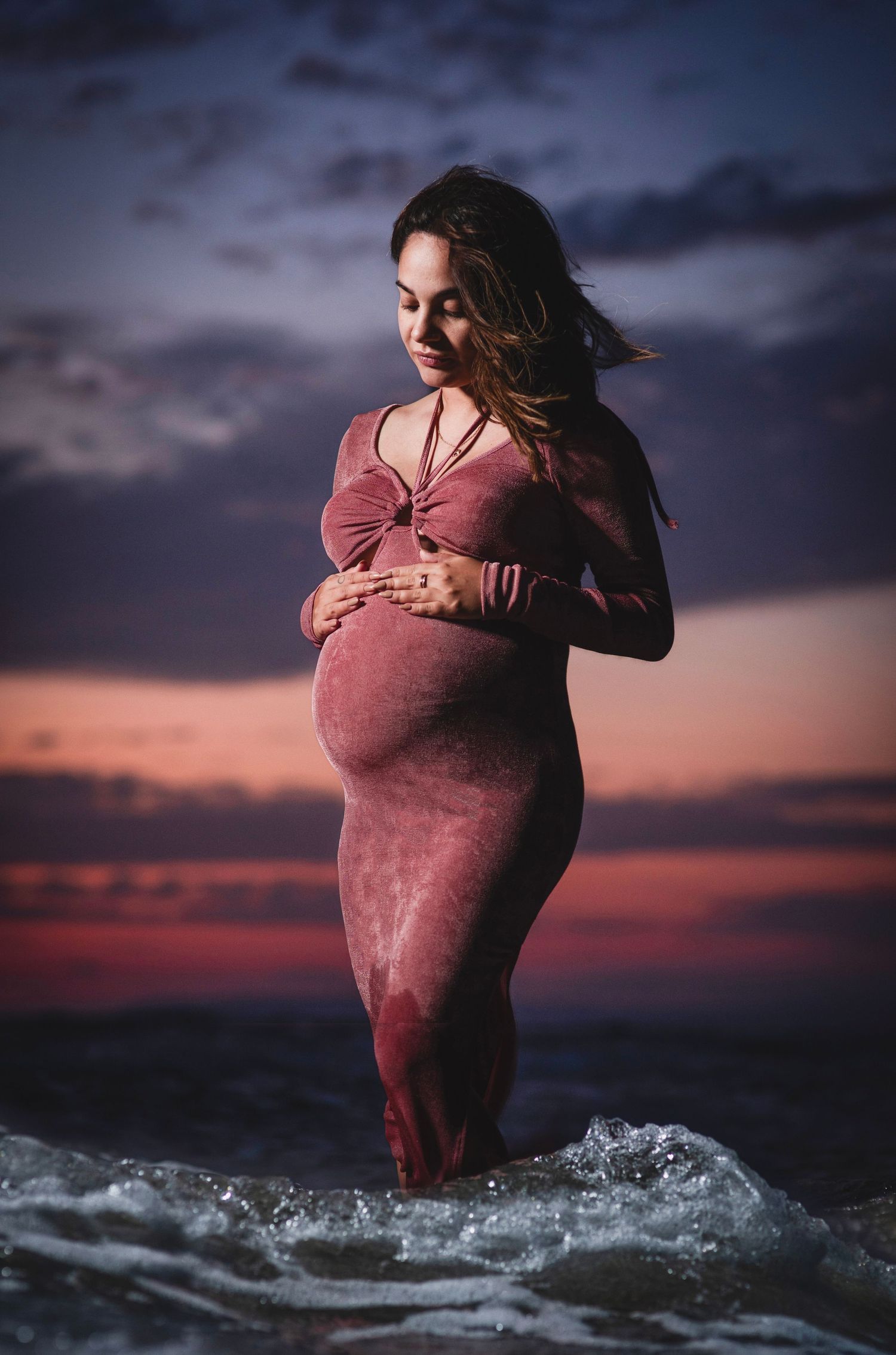 Maturnity shoot a the beach in Cyprus, posing in the sea after sunset.