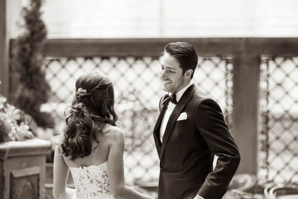 Black and white portrait of couple during first look wedding moment.