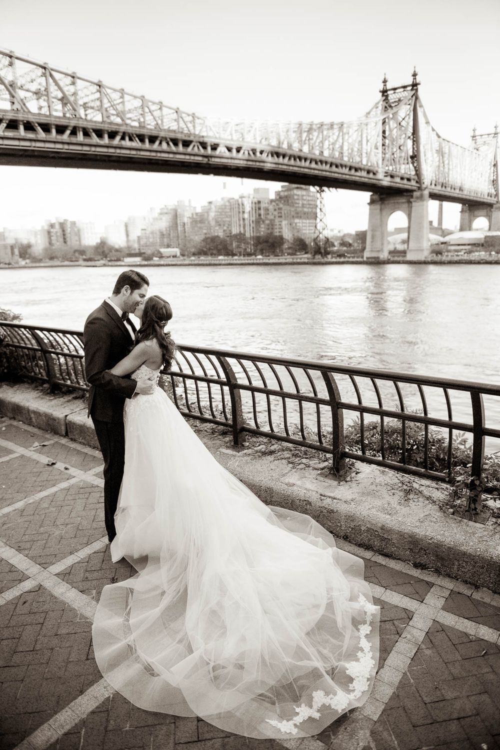 Wedding couple silhouetted against Queensboro Bridge in black and white photography.