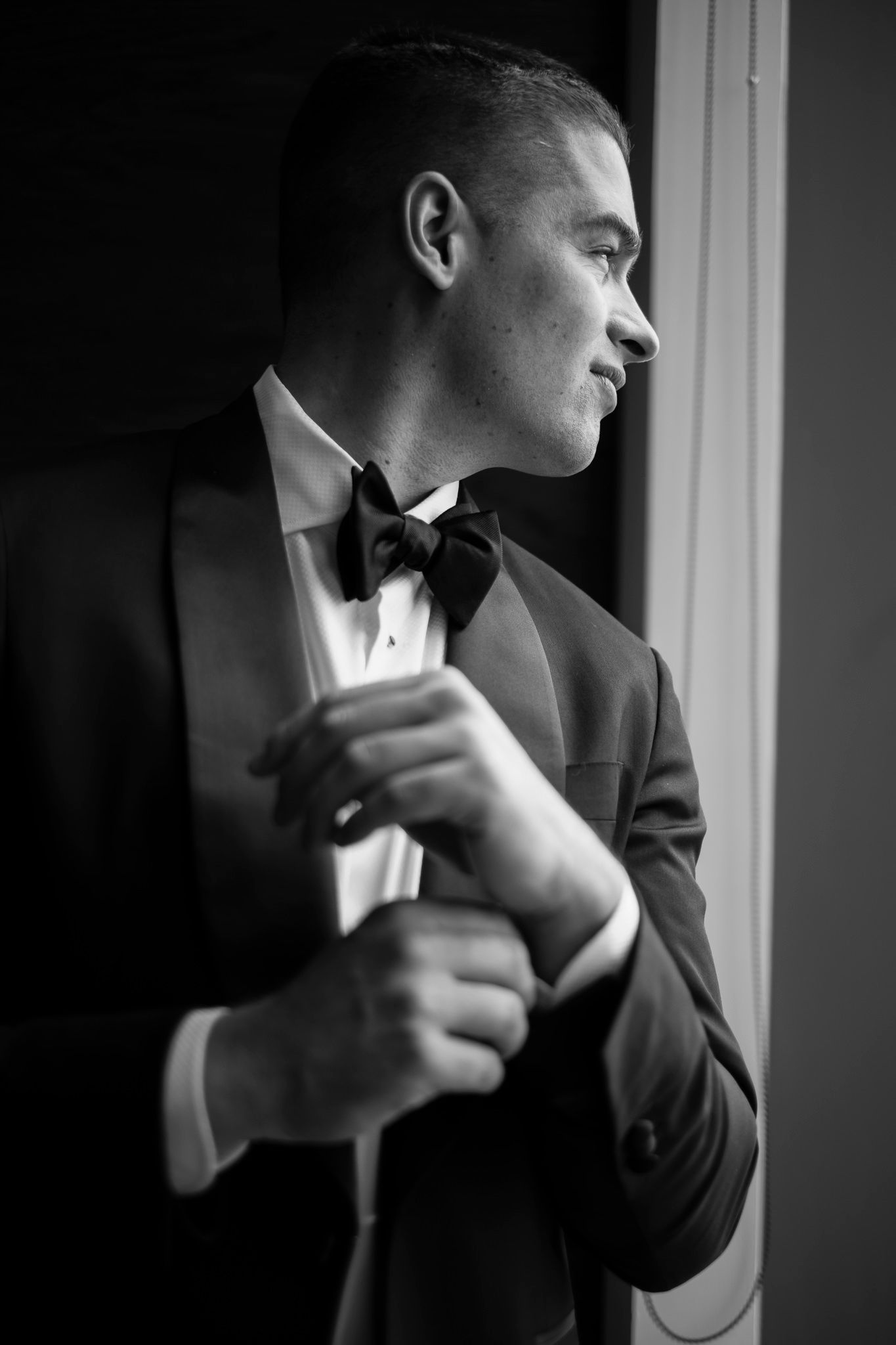 Dramatic black and white portrait series showing a person adjusting their bow tie in formal attire.