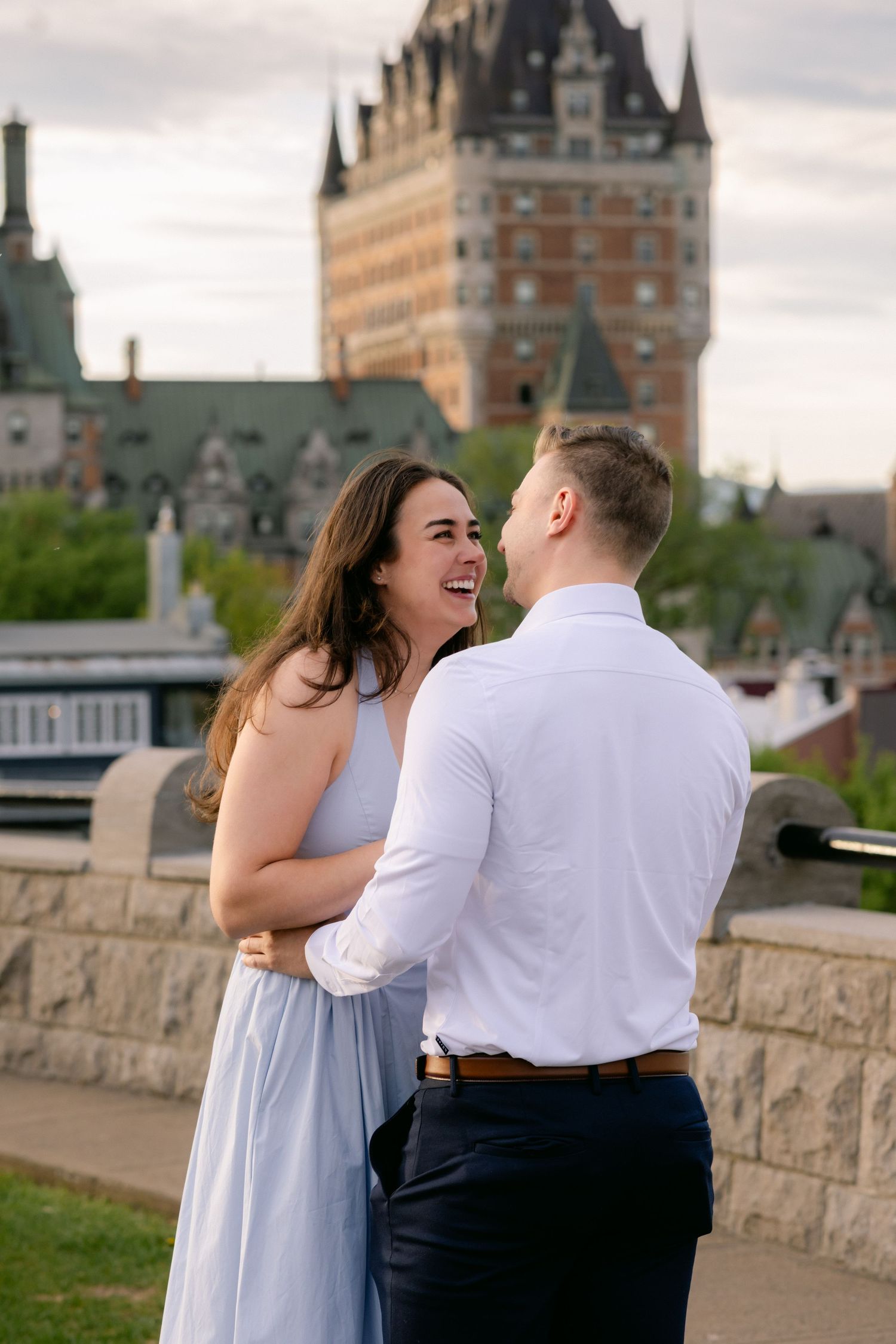 Couple embracing at sunset with Chateau Frontenac in background, Quebec City, romantic engagement photo.