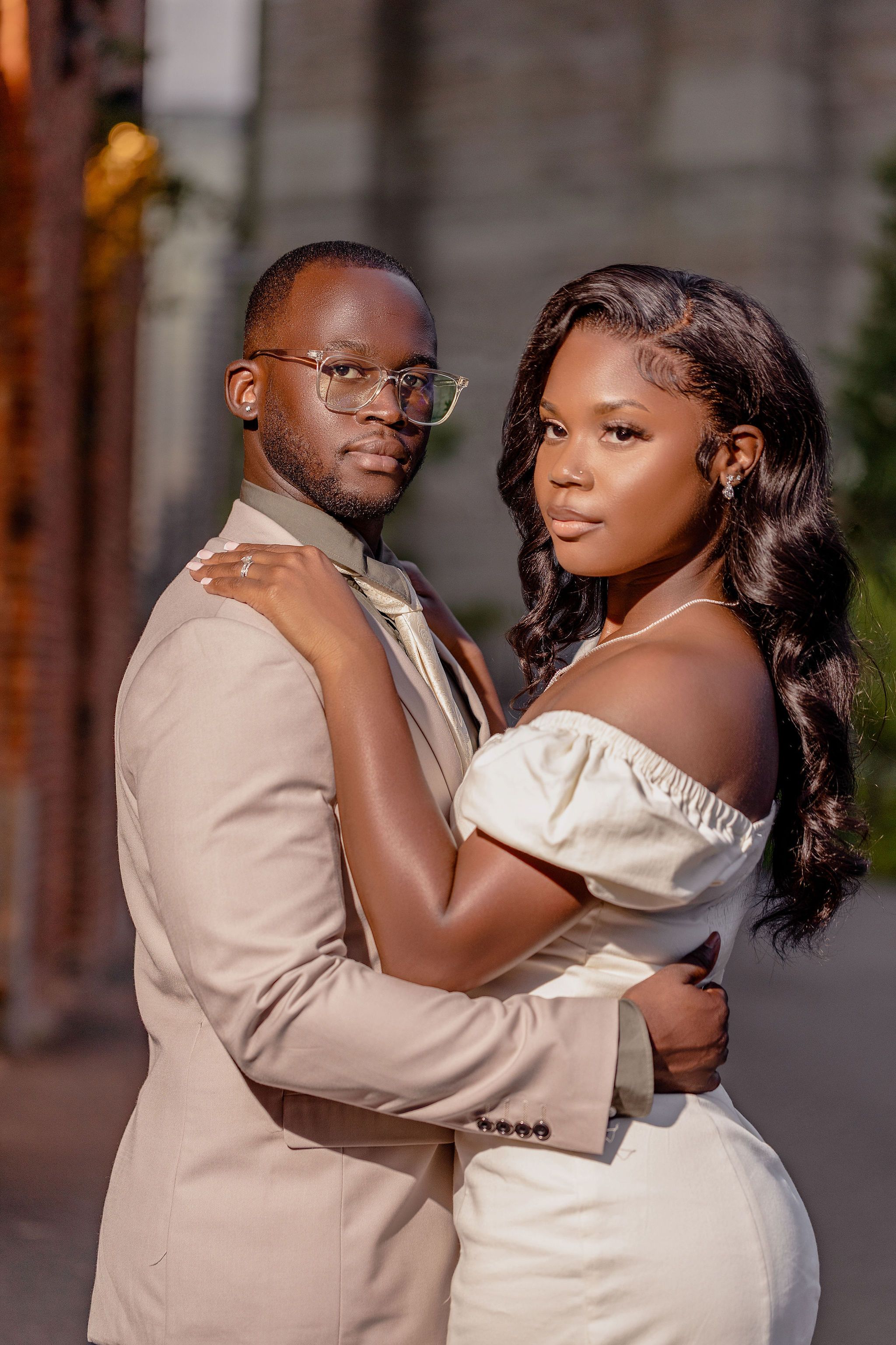 An elegant engagement portrait with soft lighting and urban architecture.