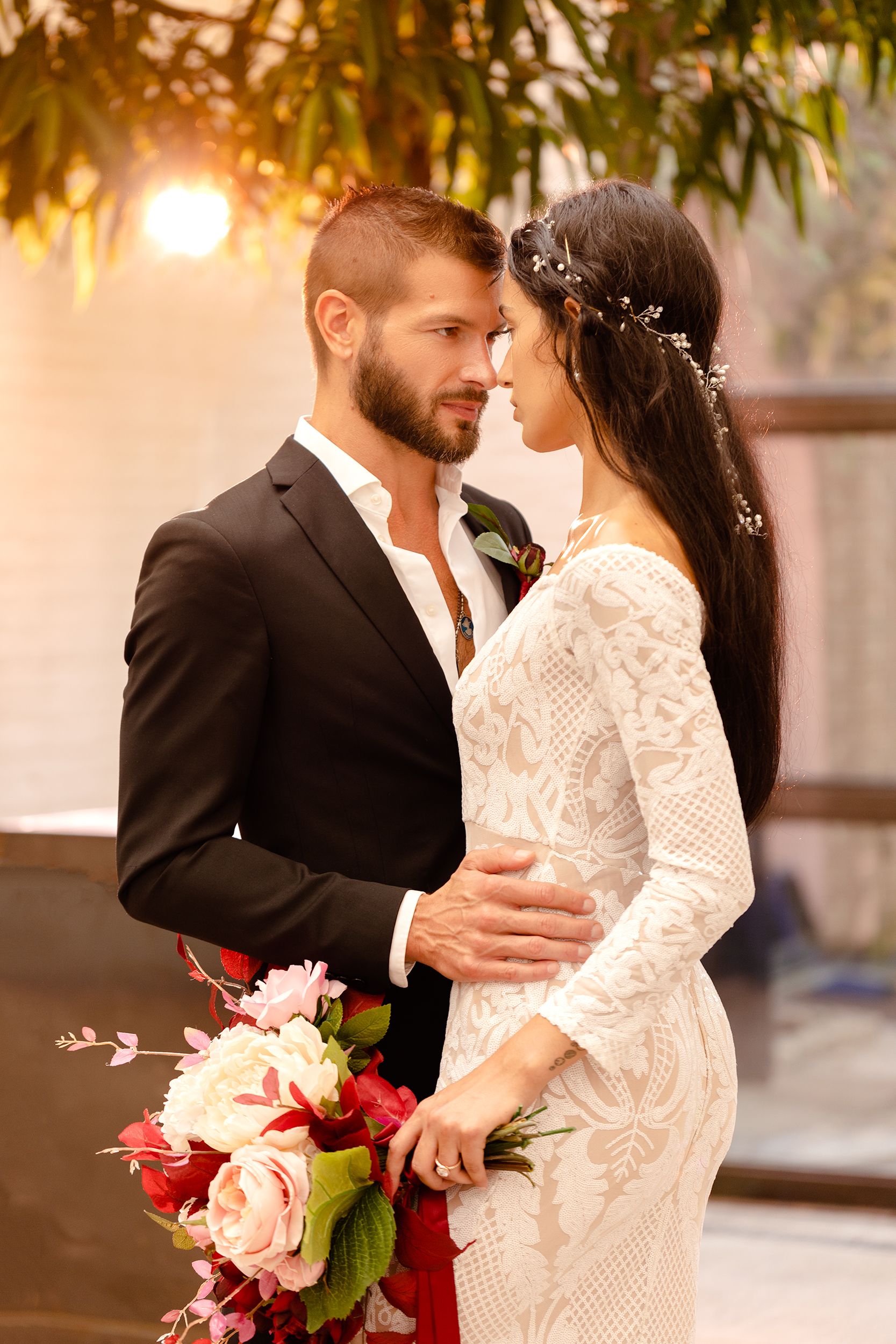 artificial golden hour or fake sunset light behind bride and groom looking at each other