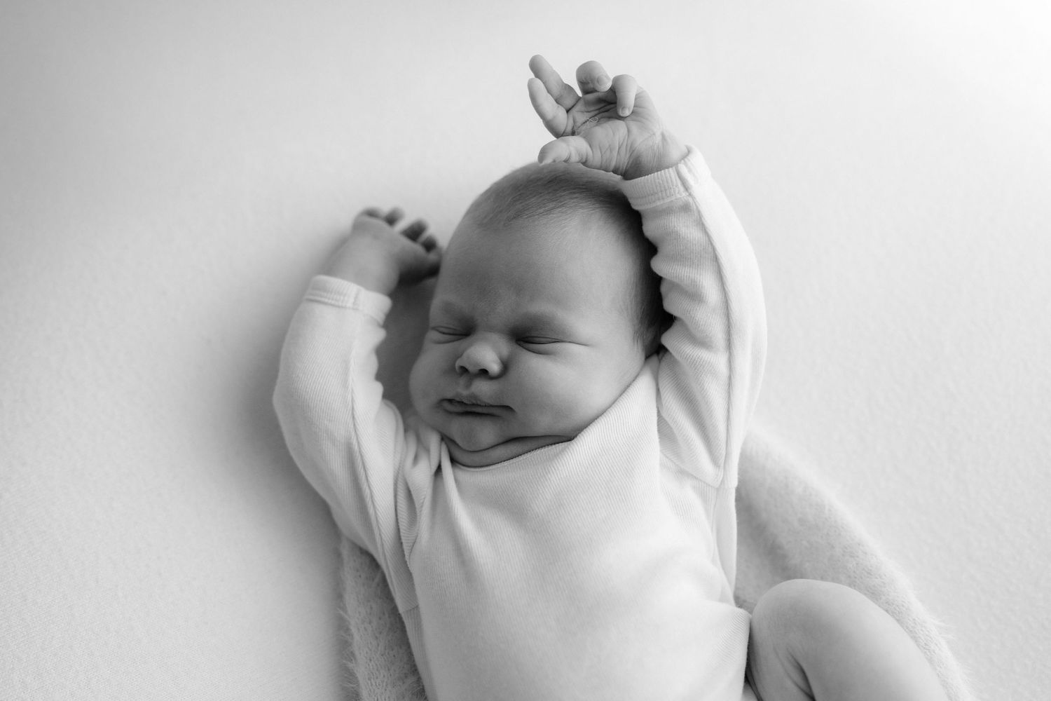baby stretching in natural pose on bean bag in home Auckland newborn session