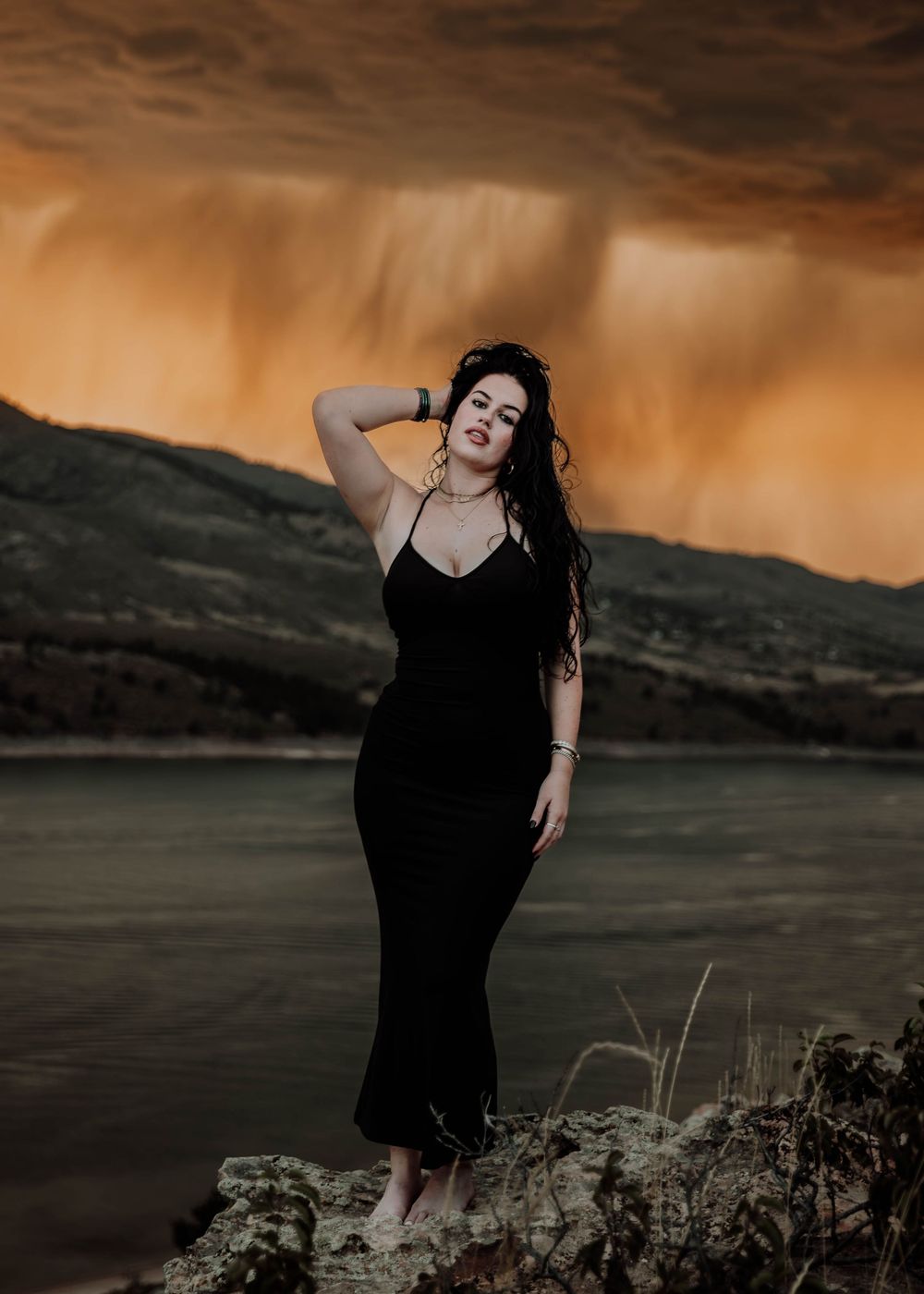 Woman poses in front of dramatic, cinematic sky for portrait and modeling photos in Fort Collins, Colorado