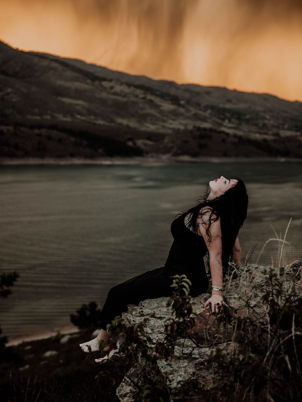Woman poses in front of dramatic, cinematic sky for portrait and modeling photos in Fort Collins, Colorado