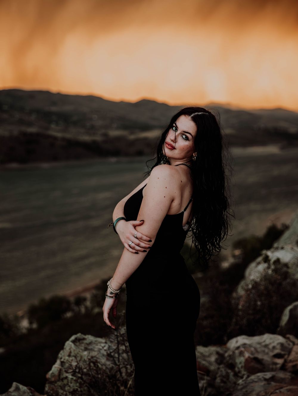 Woman poses in front of dramatic, cinematic sky for portrait and modeling photos in Fort Collins, Colorado