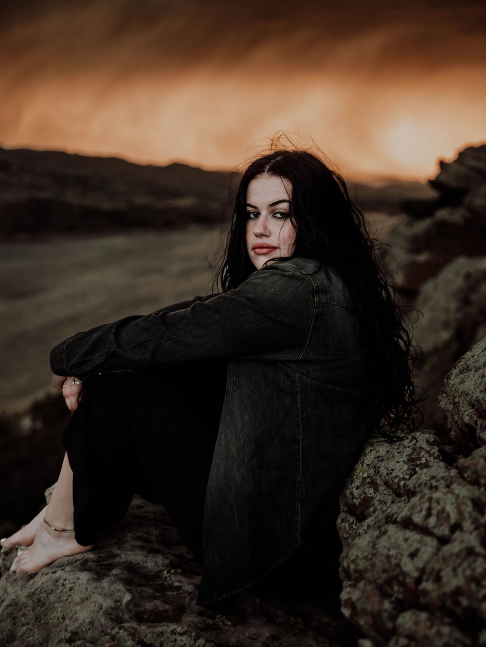 Woman poses in front of dramatic, cinematic sky for portrait and modeling photos in Fort Collins, Colorado