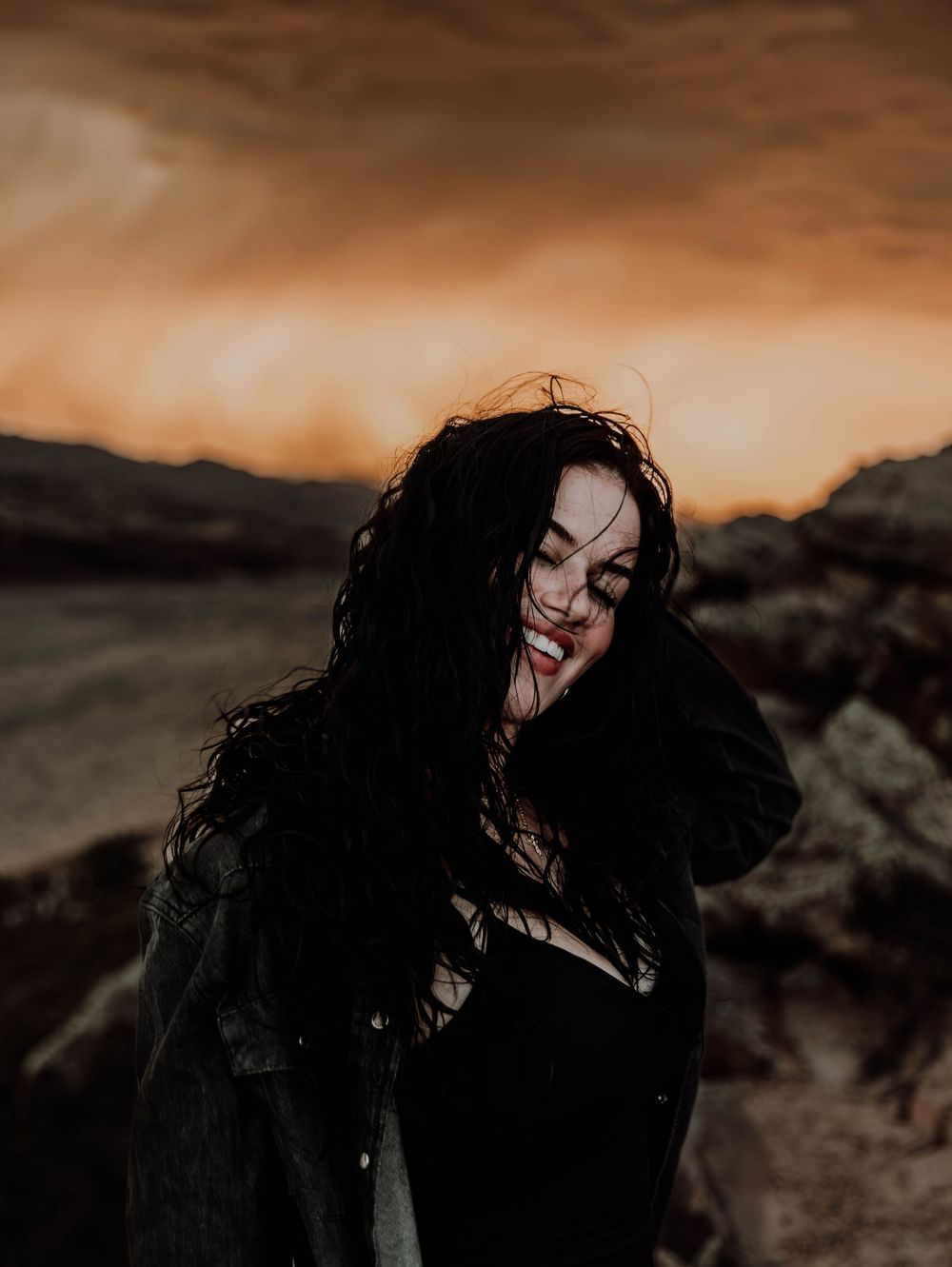 Woman poses in front of dramatic, cinematic sky for portrait and modeling photos in Fort Collins, Colorado