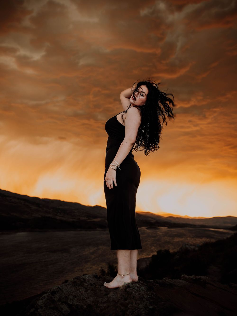 Woman poses in front of dramatic, cinematic sky for portrait and modeling photos in Fort Collins, Colorado