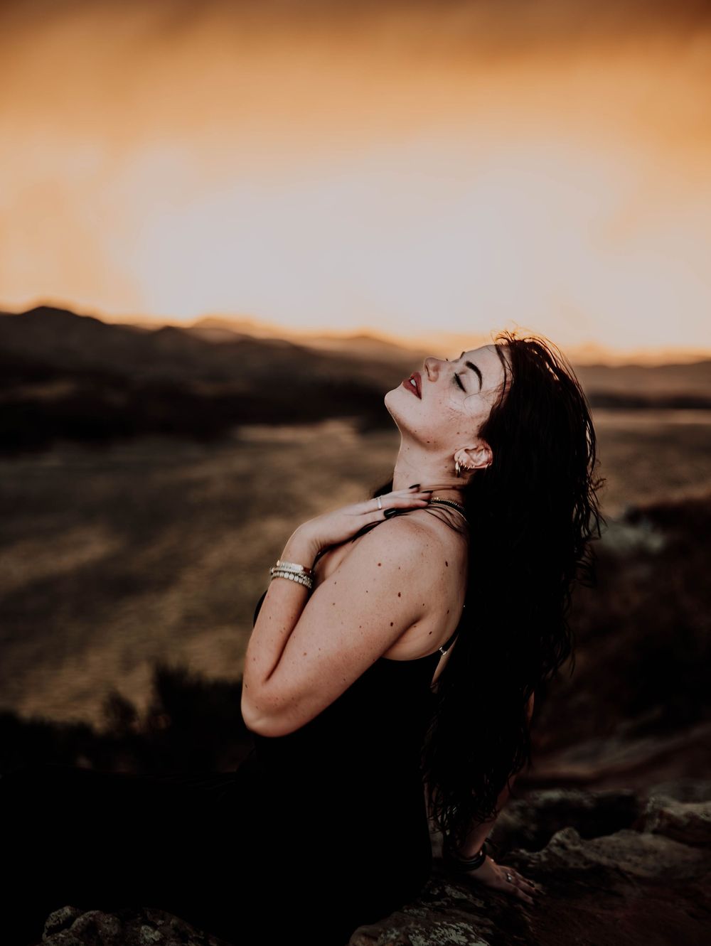 Woman poses in front of dramatic, cinematic sky for portrait and modeling photos in Fort Collins, Colorado