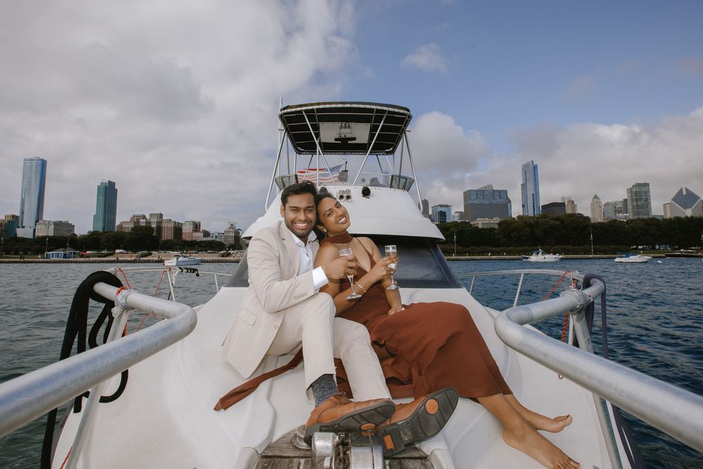 Couple posing romantically on a white boat with Chicago skyline in the background on a cloudy day.