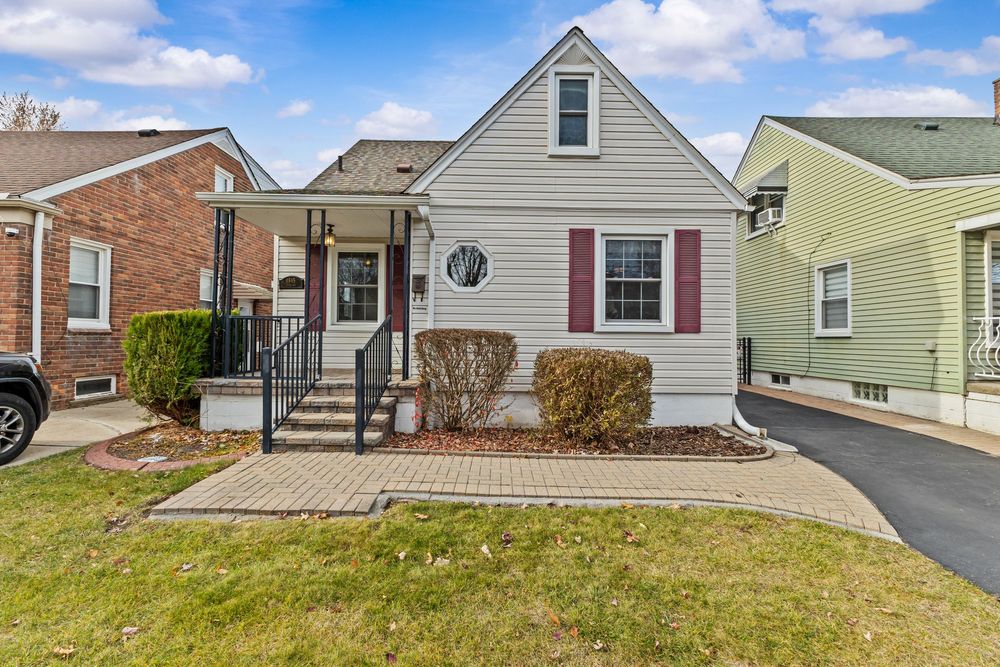 Cape Cod style home with covered porch and brick paver walkway on Westland Street Dearborn Michigan