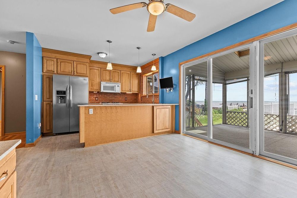 Spacious kitchen with oak cabinetry, center island, and sliding glass doors to outdoor deck.