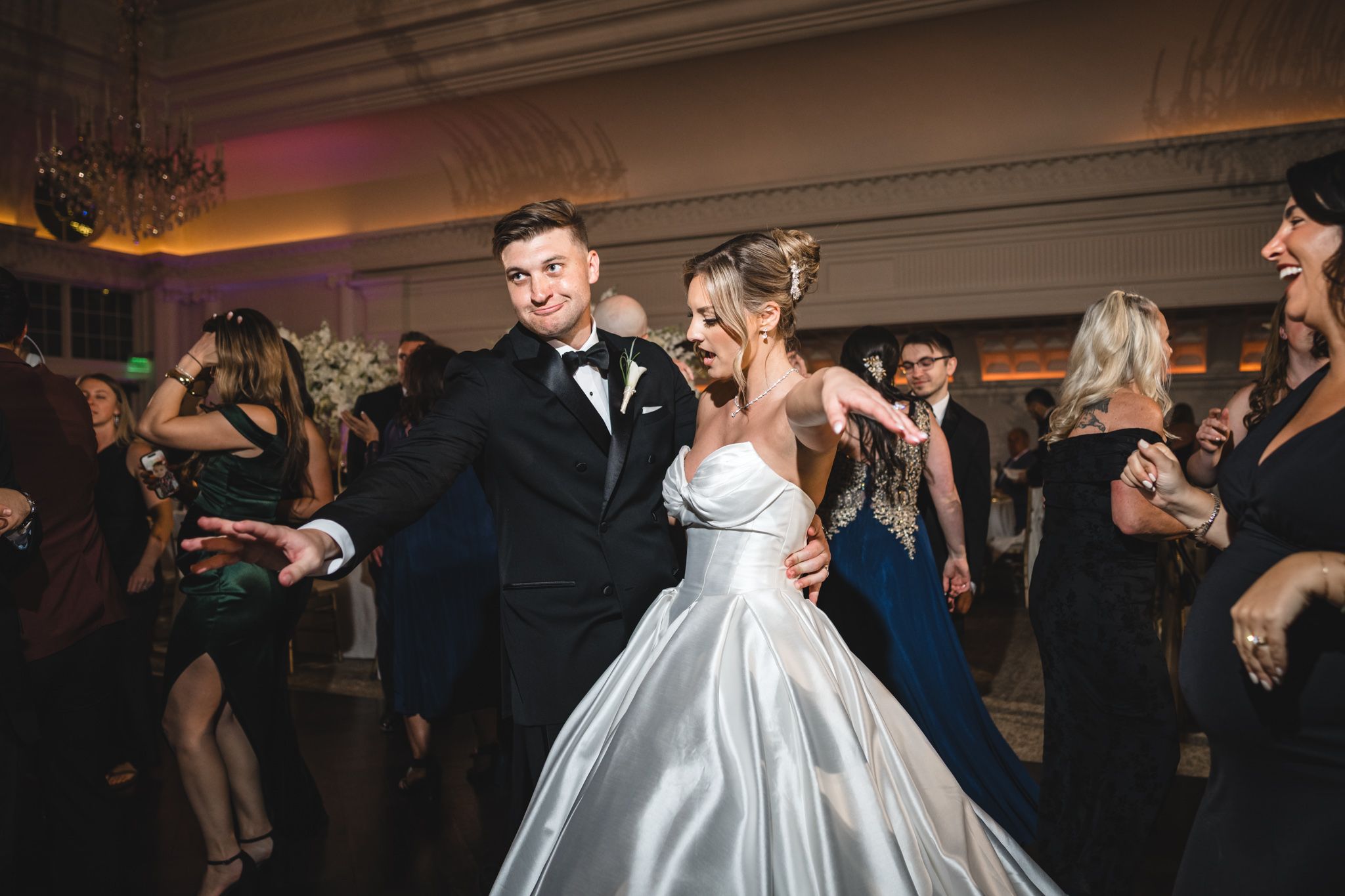 Bride and groom dancing together at elegant wedding reception in ballroom.