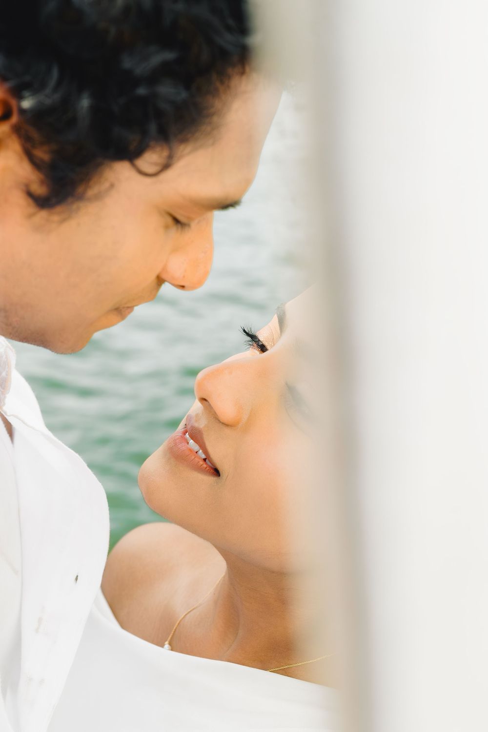 A close-up shot captures an intimate moment between a couple on a boat.