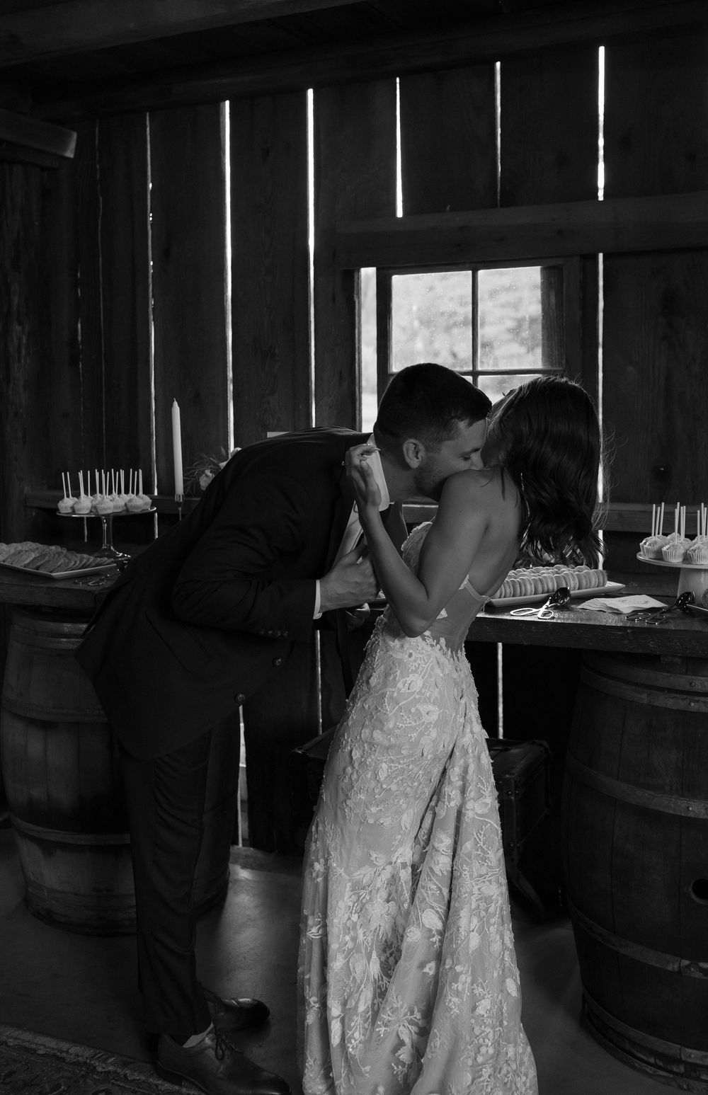 Black and white photo series showing a couple's first dance in a rustic barn setting.