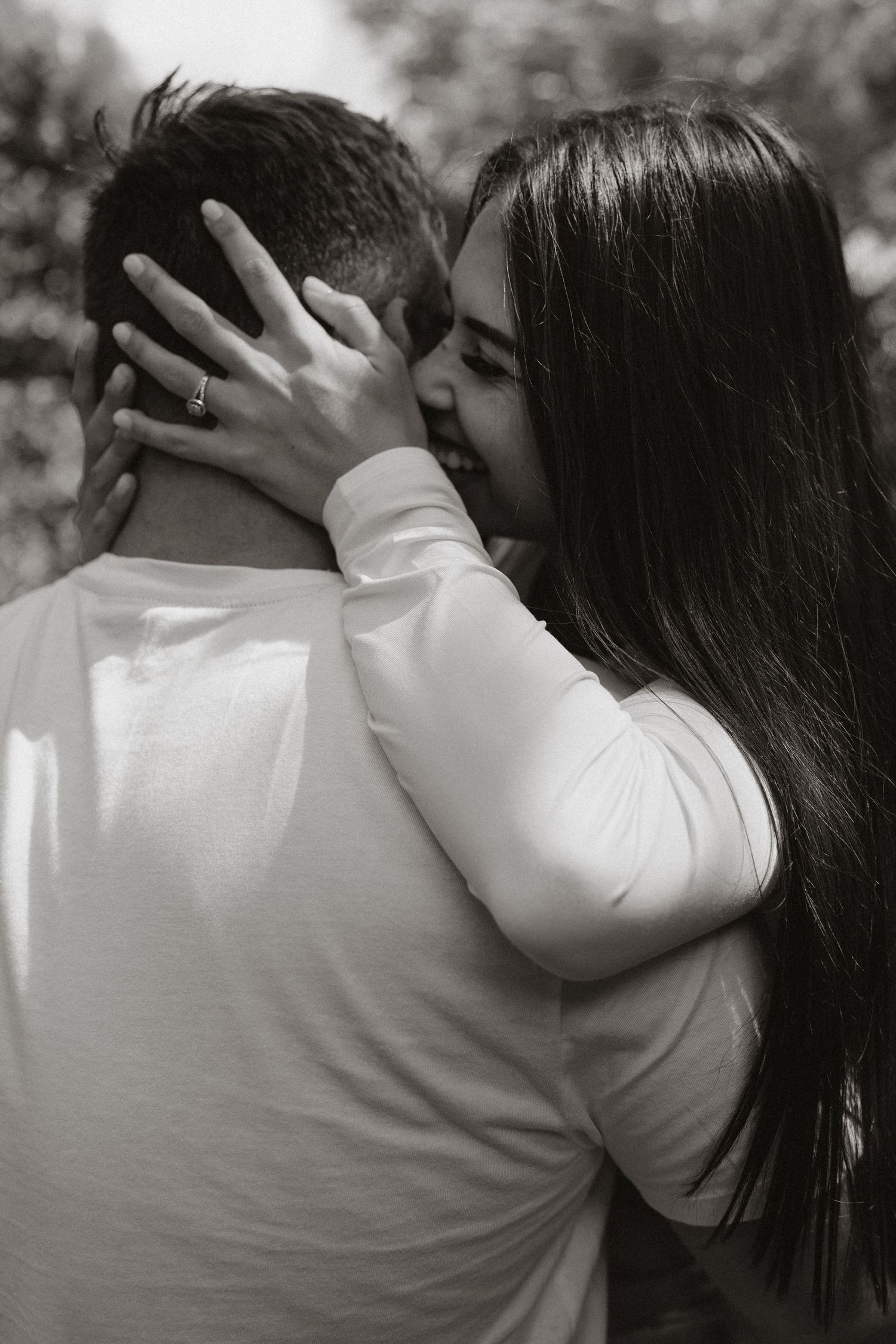 Intimate black and white portrait of a couple embracing in a tender moment.