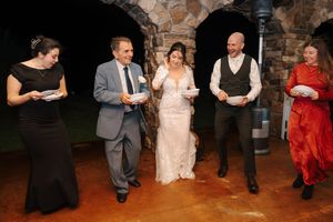 Wedding guests dancing and socializing in a rustic brick-walled venue during a reception celebration.