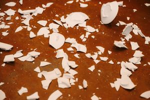 White flower petals scattered across a dark wooden floor create a romantic wedding decoration pattern.