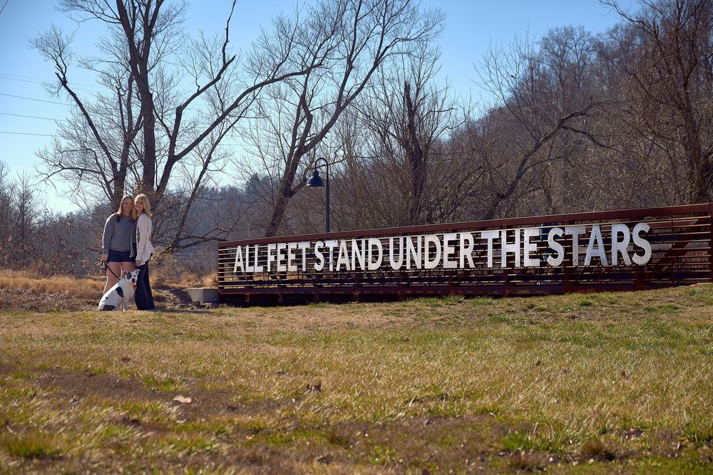 Scenic fall landscape with wooden fence and 'Stand Under the Stars' signage during golden hour photography session.
