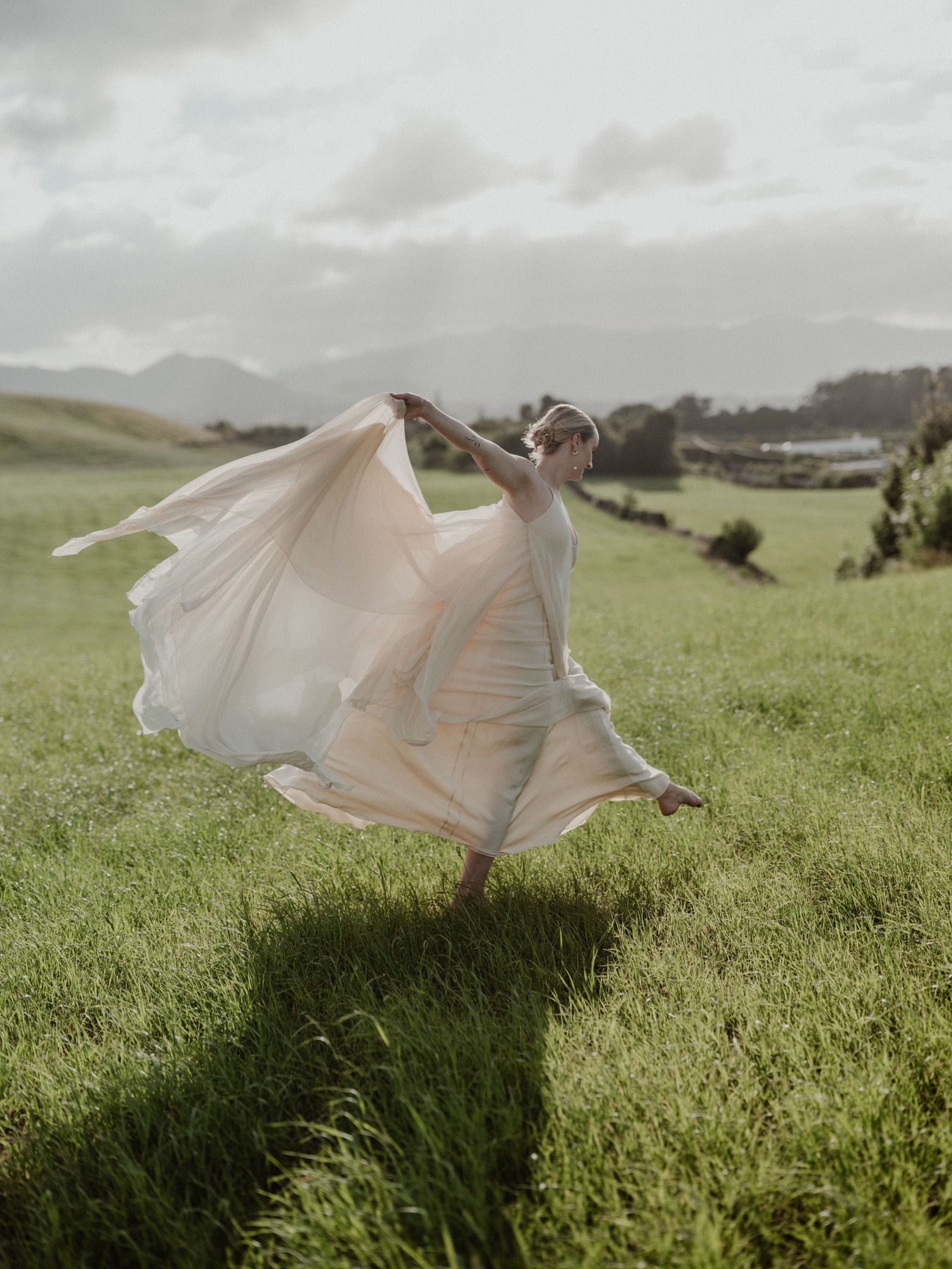 Bride running through a green field during a destination wedding in Porto, Portugal, natural movement and documentary approach