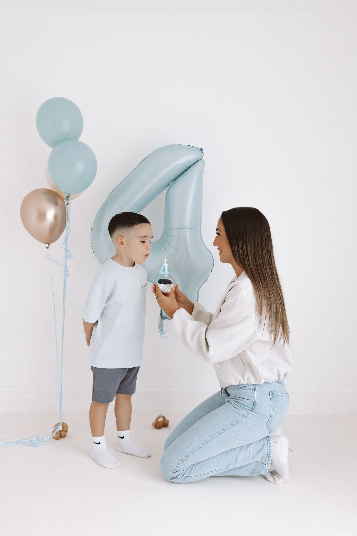 A family sits together in a bright white room for a casual portrait session.