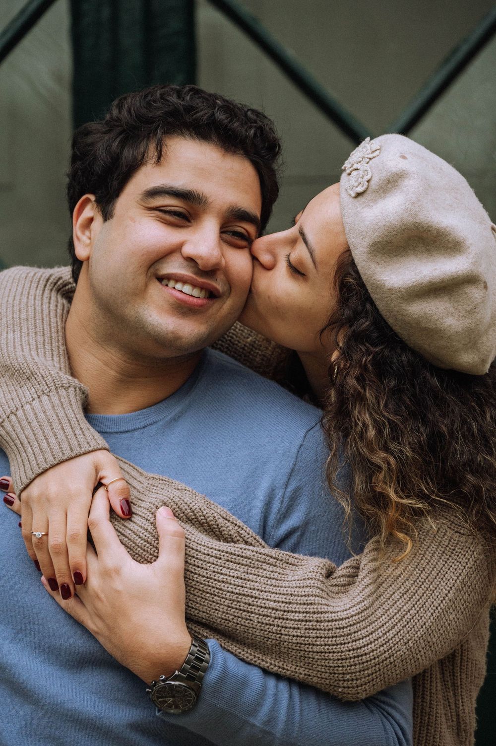 Intimate close-up portrait of a couple embracing and sharing a tender moment against a dark background.
