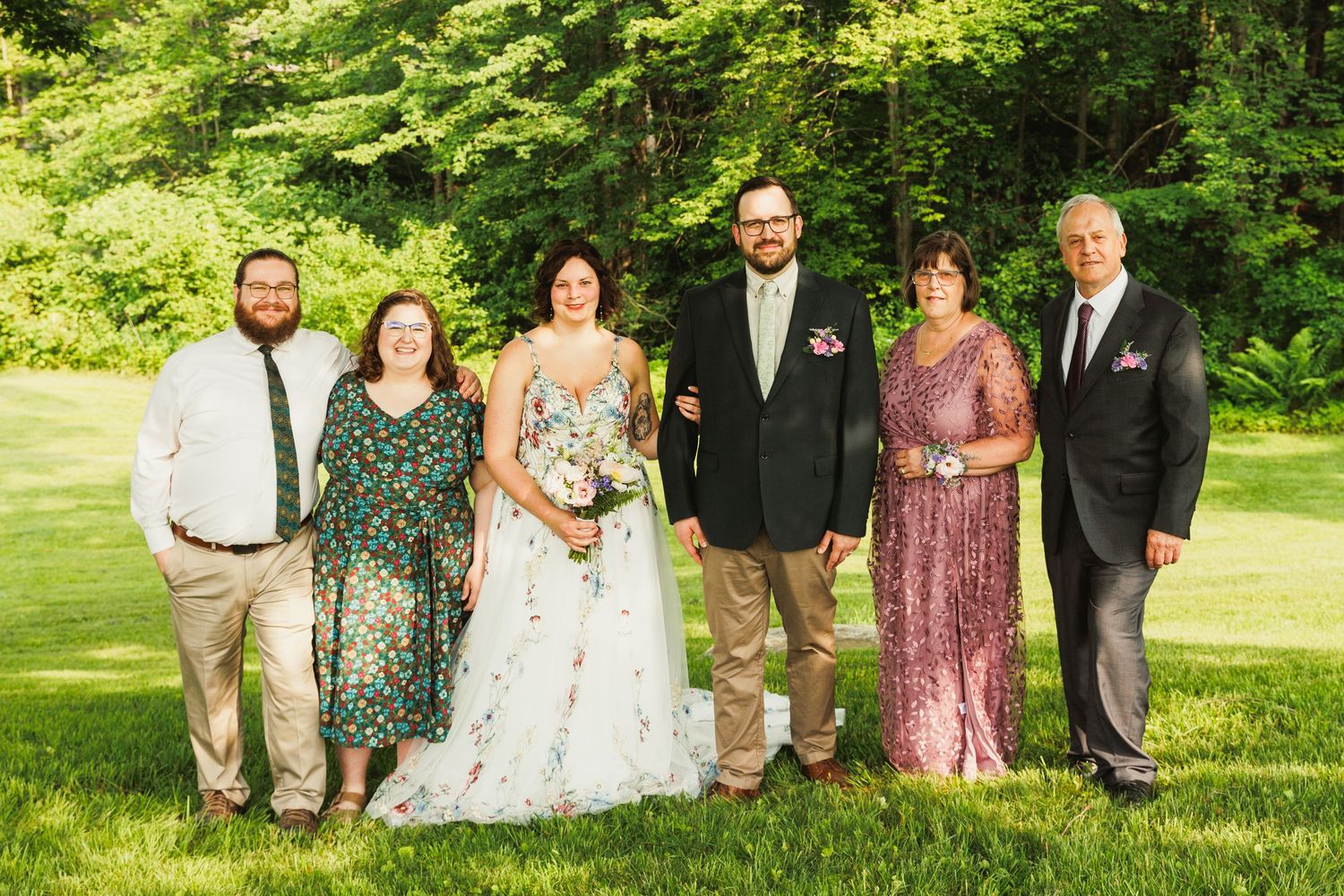 Wedding party group photos taken outdoors in a lush green garden setting with coordinated formal attire.