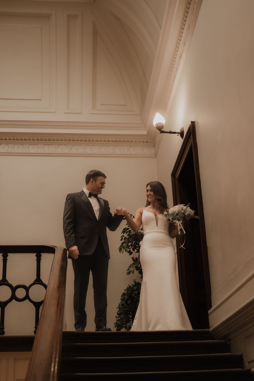 A sequence of wedding photos showing a couple in formal attire standing on stairs in a vintage-style setting.