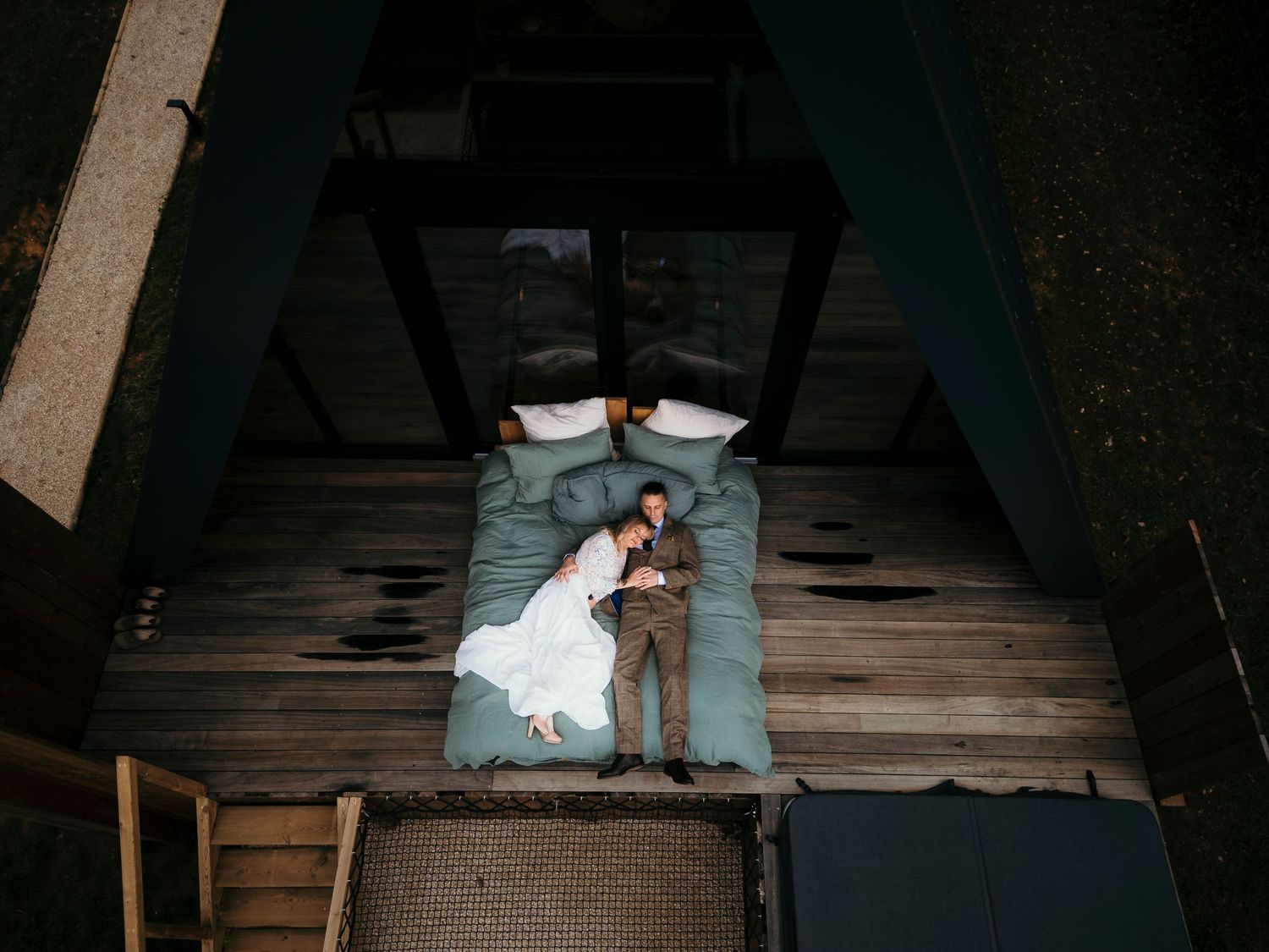 A romantic black and white wedding photograph showing a tender embrace in a natural outdoor setting.