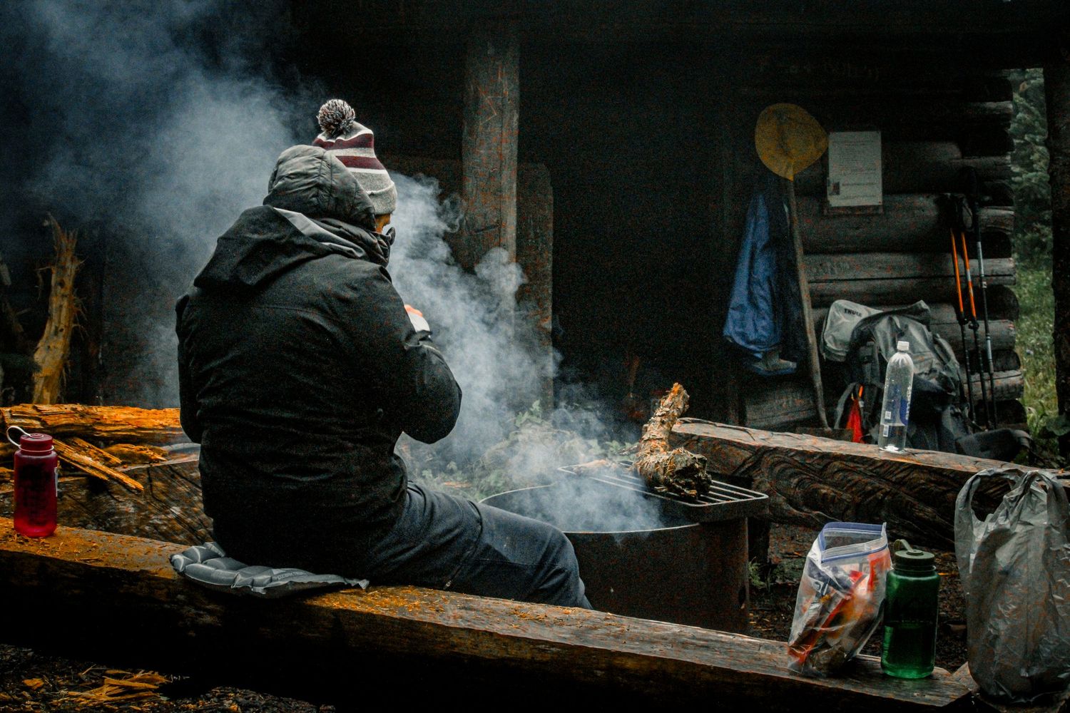 Atmospheric scene of campfire smoke drifting through a dark outdoor setting.