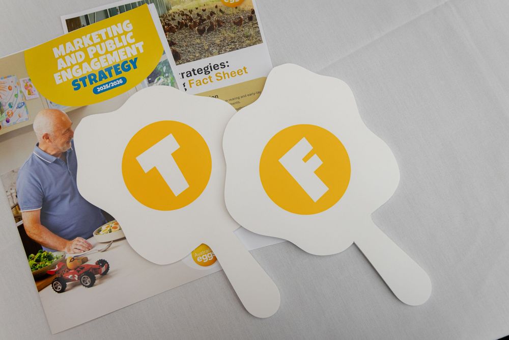 Collection of branded promotional items and marketing materials with yellow speech bubble designs laid out on a gray surface.