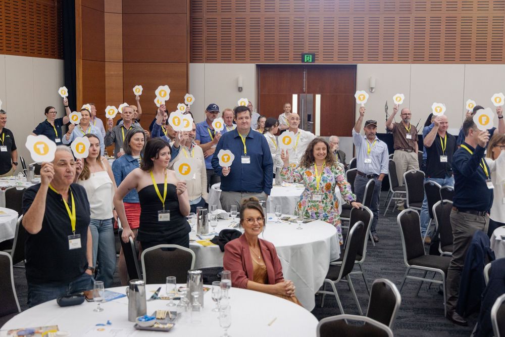 Fremantle Conference Photographer captures Conference attendees seated at round tables during a professional event.