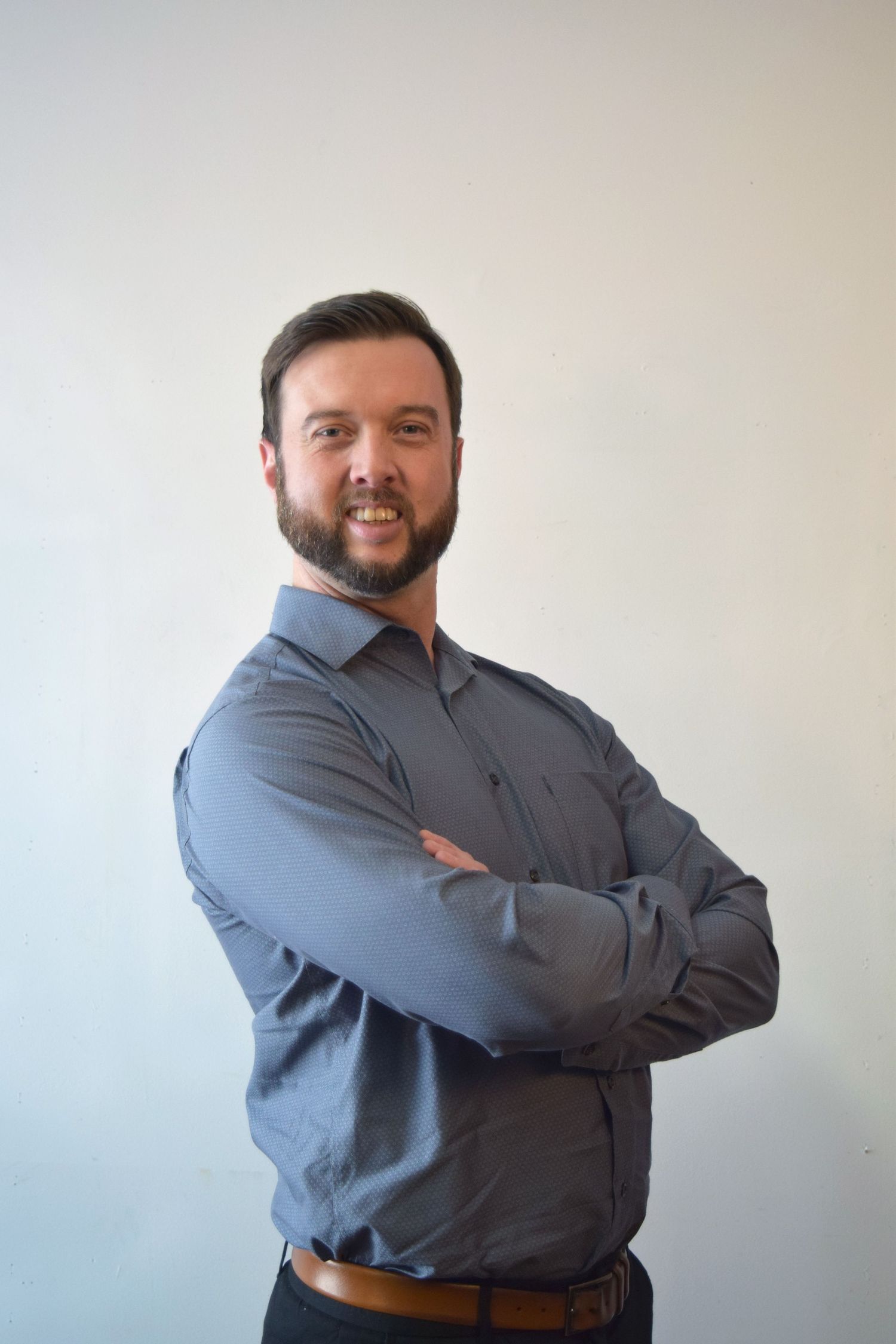 Professional headshots of person in business attire against gray background shown from different angles.