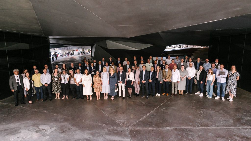 Foto de grupo de asistentes reunidos en interior durante evento corporativo