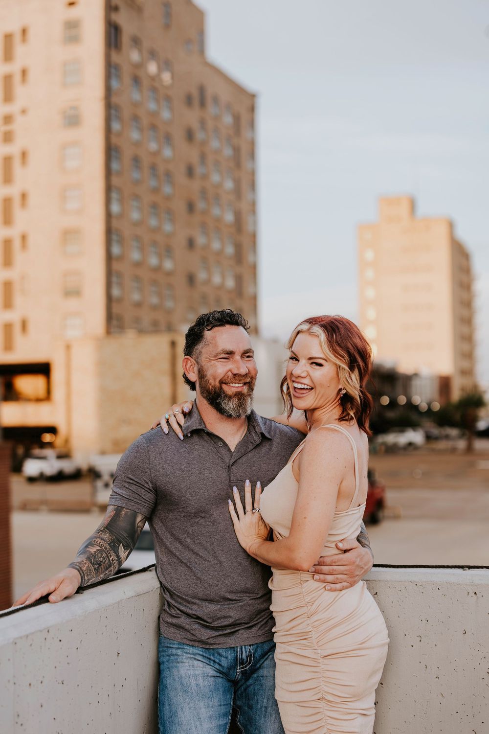 Candid moments of laughter and love captured during rooftop photoshoot at golden hour.